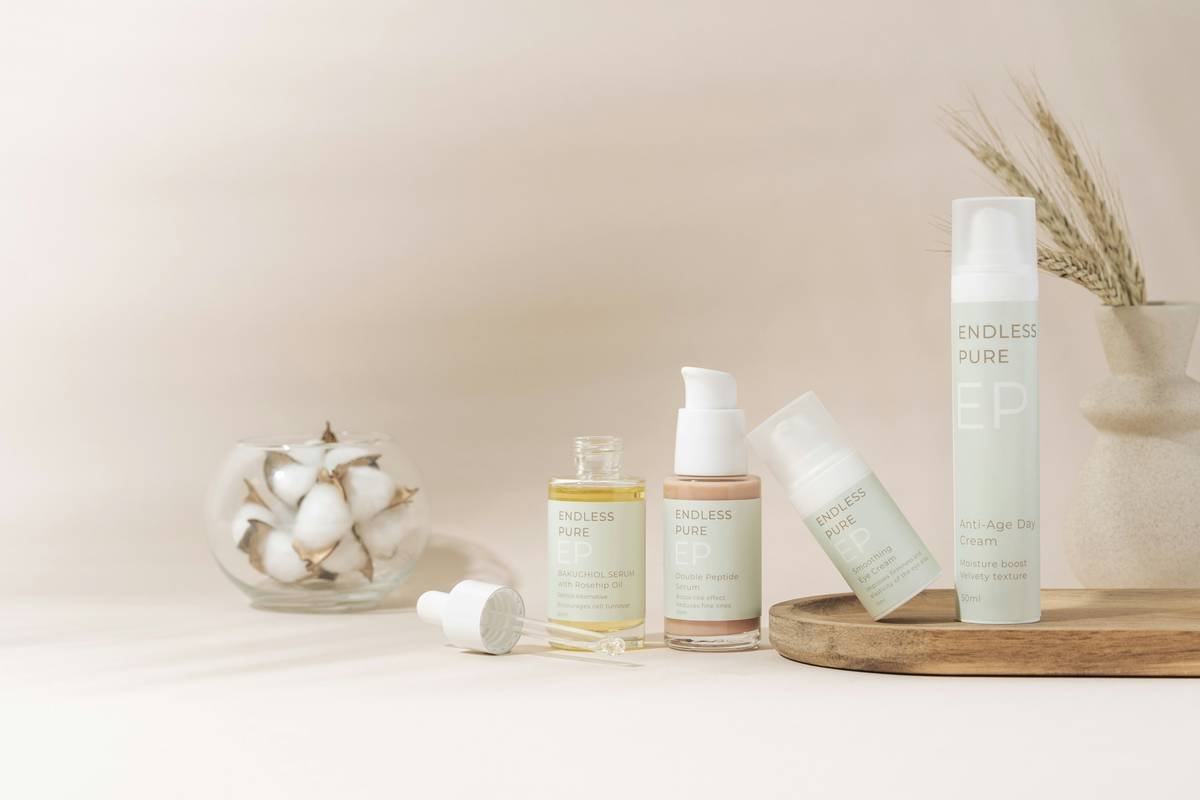 Close-up of dewy, calm skin with a bottle of clean ingredient beauty botanical skincare gentle serum beside it