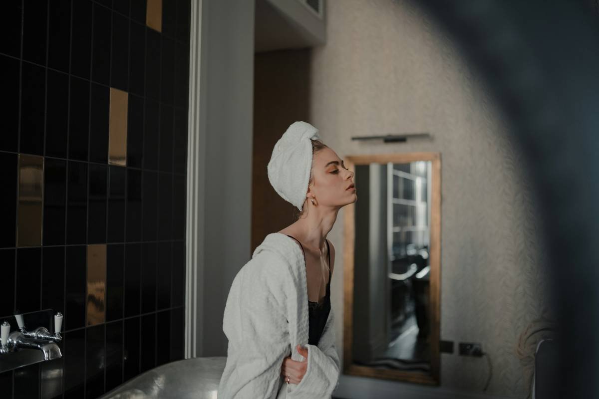 Woman applying non-toxic moisturizer as part of her clear skin care routine